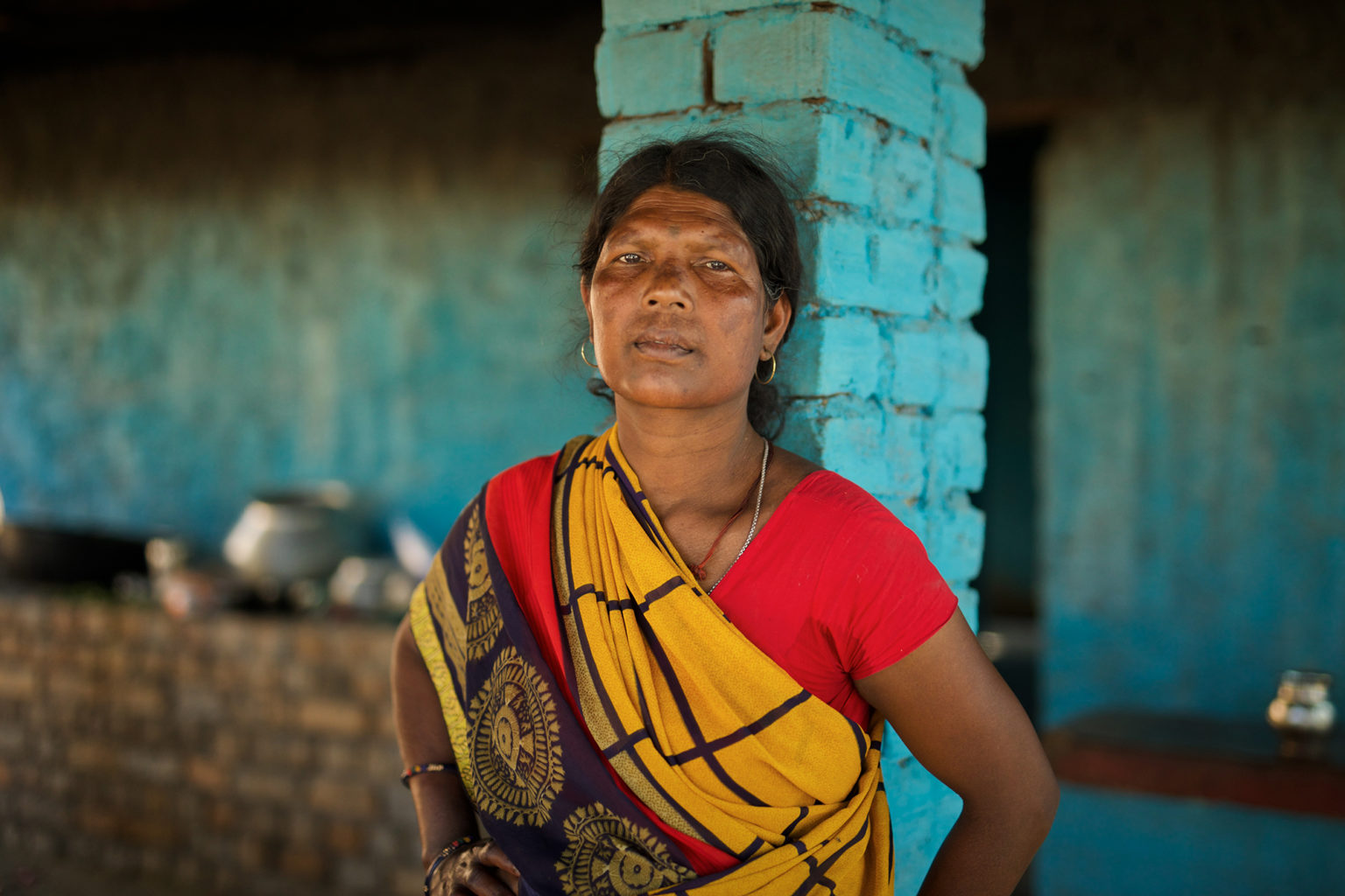 A photo of a woman leaning against a pillar