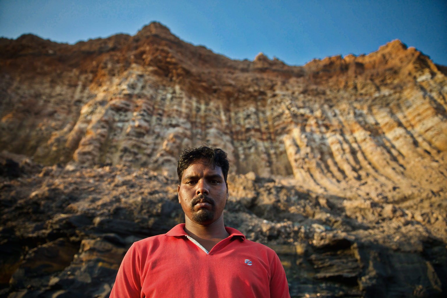 A picture of a man looking at the camera outside a coal mine