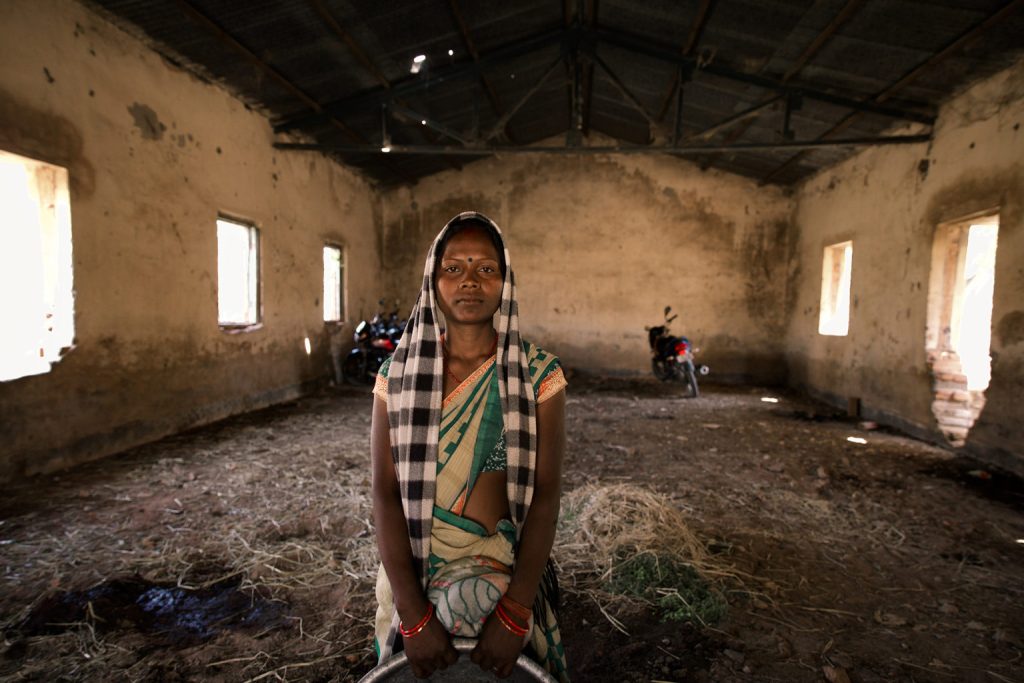 A photo of a woman standing in an abandoned building_coal mining