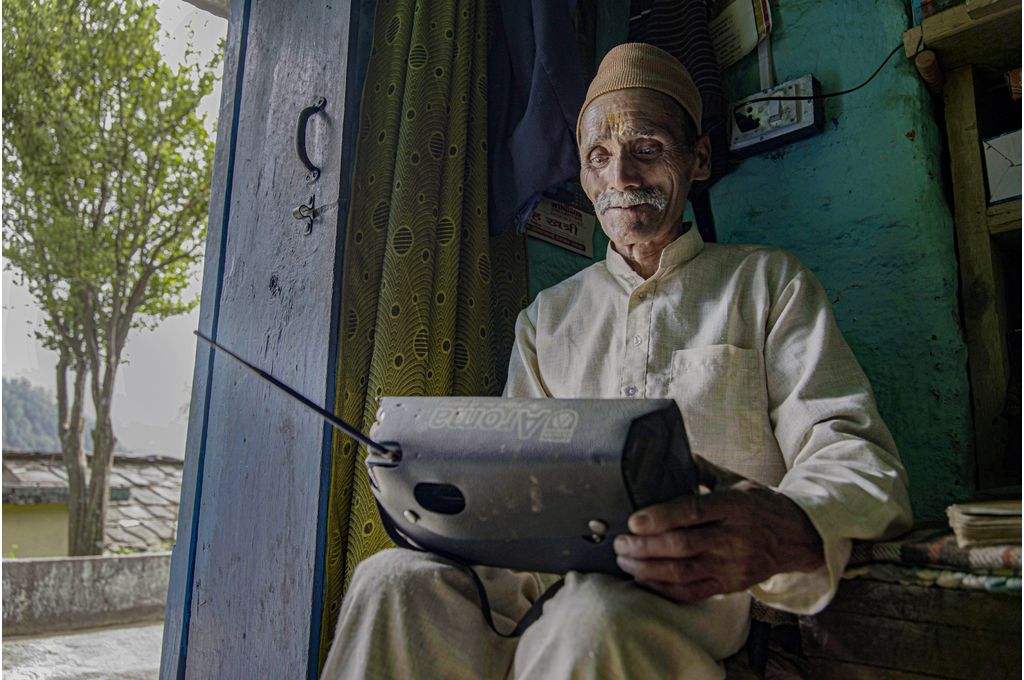 Yogambar Singh Rawat, a retired school teacher in Uttarakhand’s Rudraprayag district, tunes into a community radio station-climate