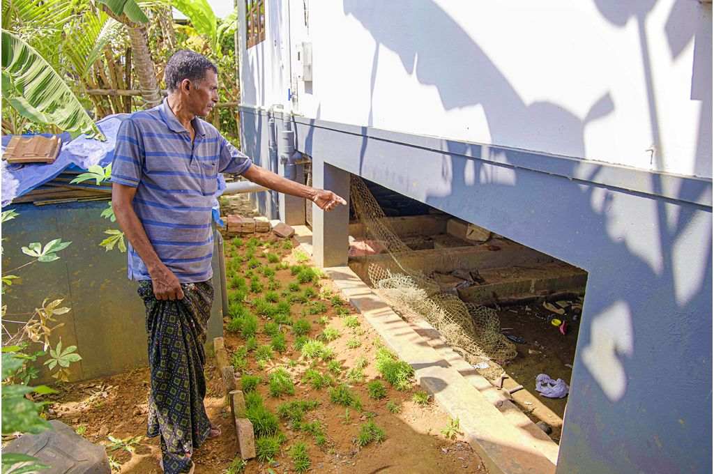 Thomas Joseph points at the raised foundation of his new house-climate