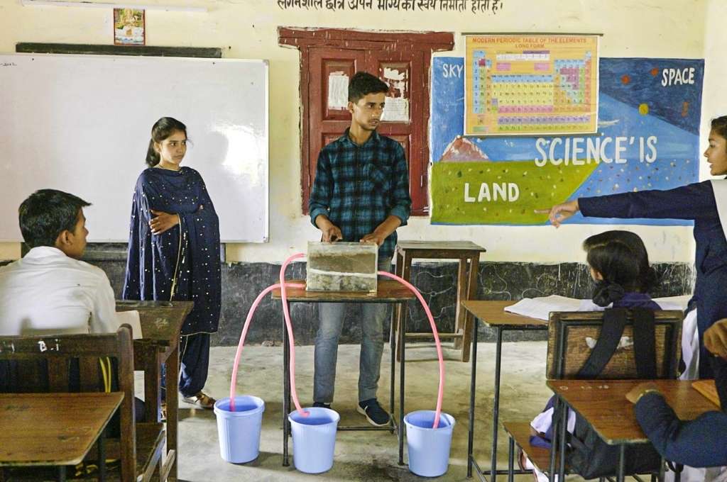 Heera and Chandan demonstrate water conservation and spring recharge techniques to school students in Suda village of Nainital district in Uttarakhand-climate