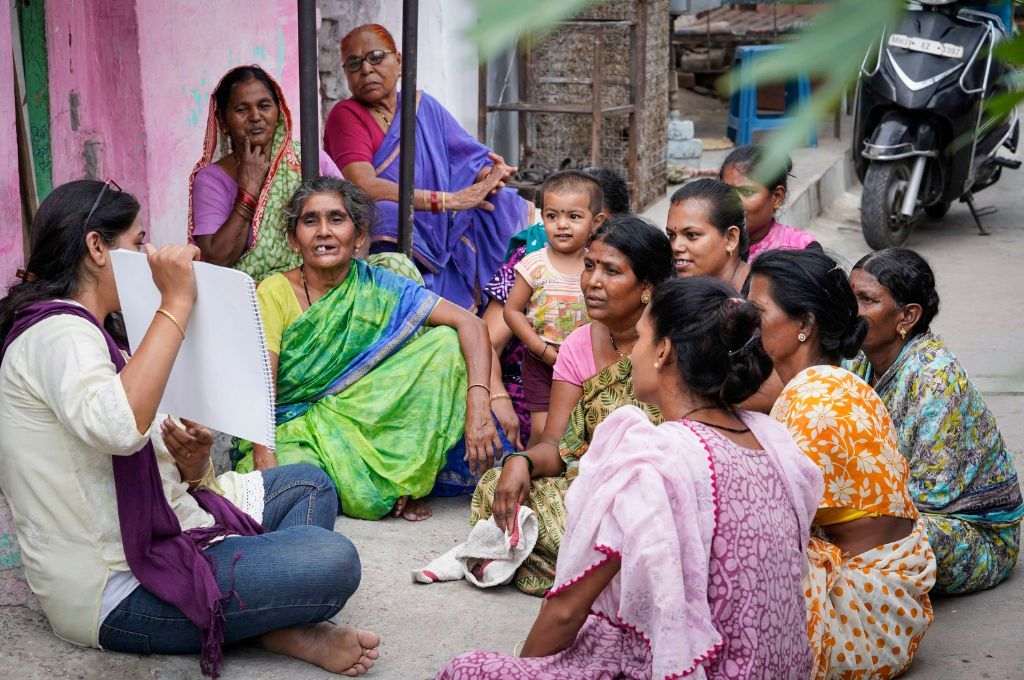 Women at a courtyard looking at a poster being displayed_air pollution