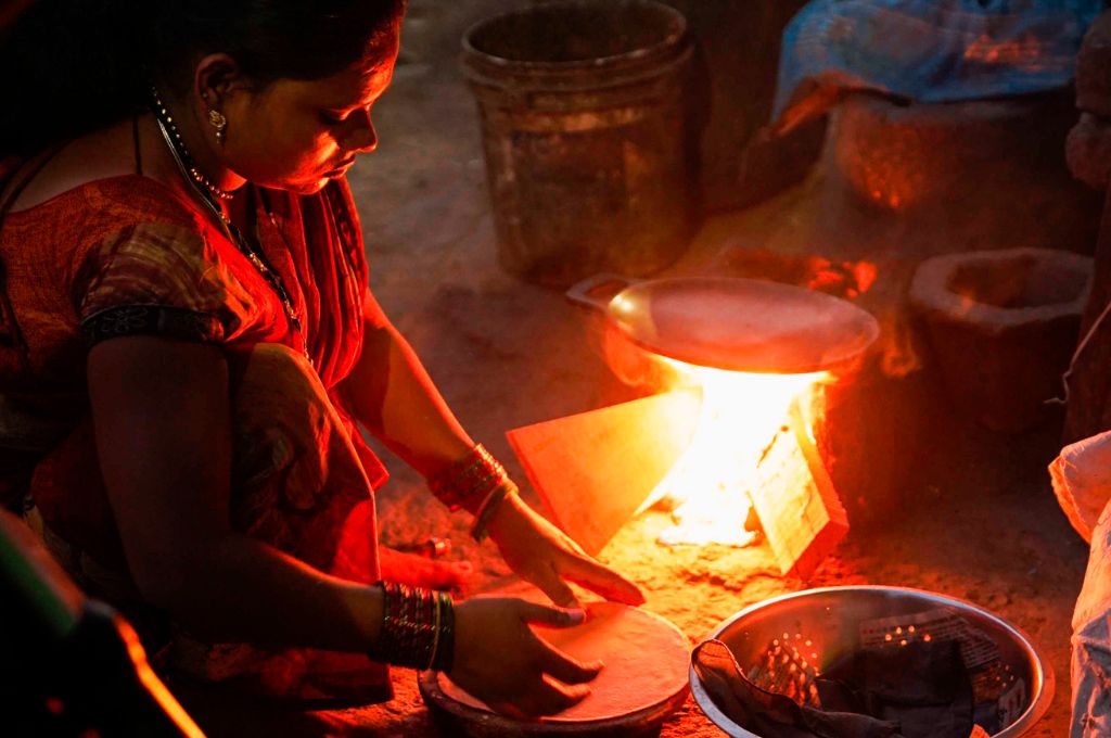 A woman making roti in front of a firewood chulha_air pollution