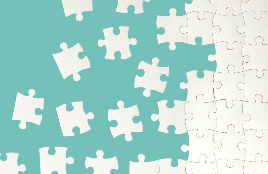 White puzzle pieces against green background-fundraising