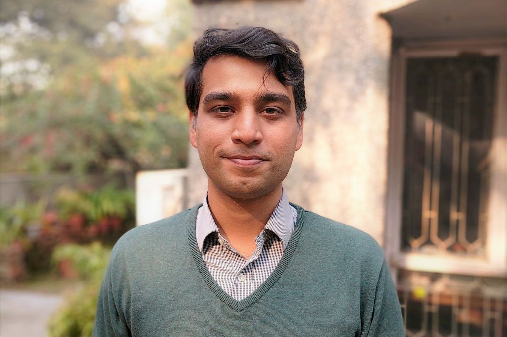 A photo of Aditya Pillai in a green sweater--climate action