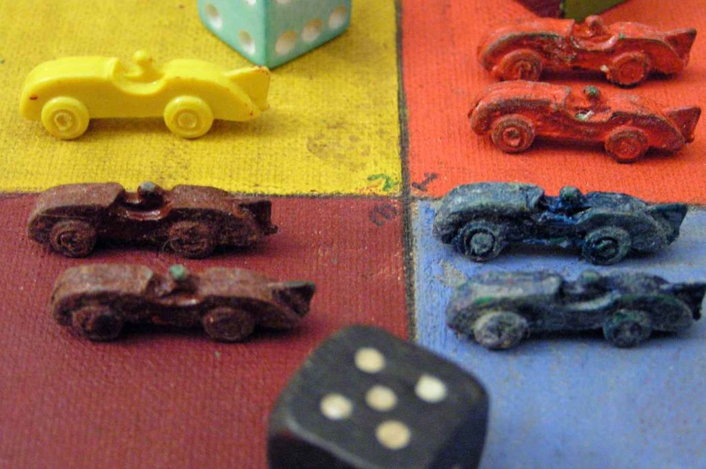 a board game with colourful dice and miniature cars on a board_climate action