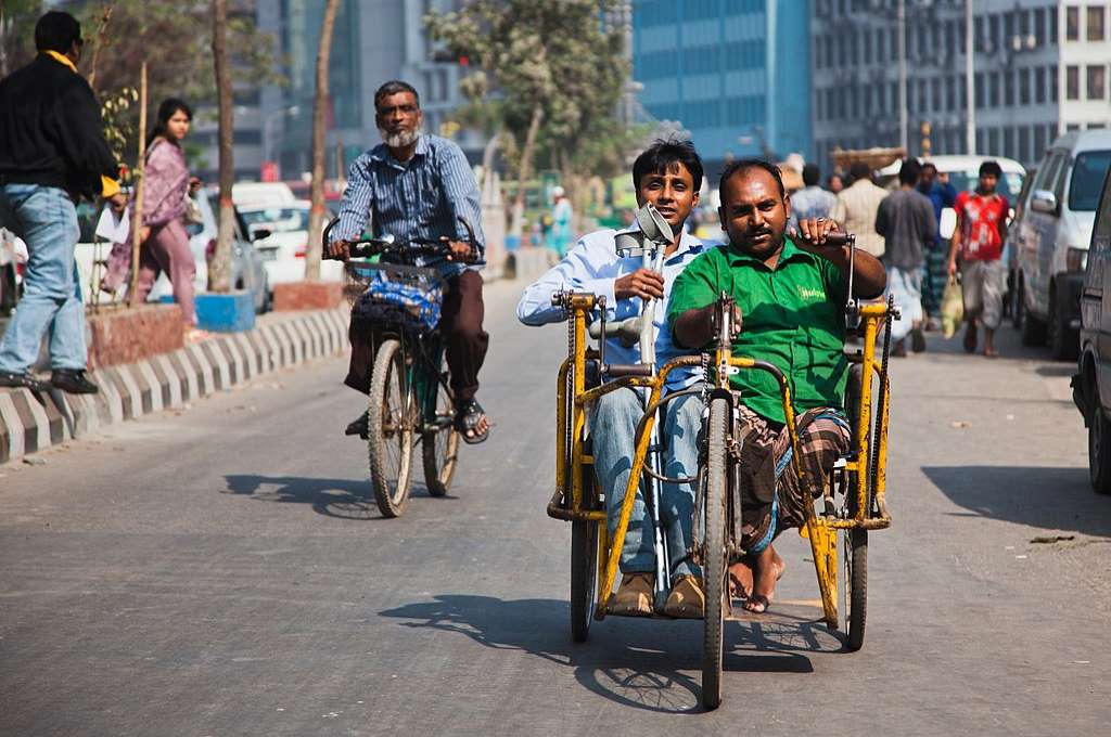 Two men in a wheelchair on the road_disabled people