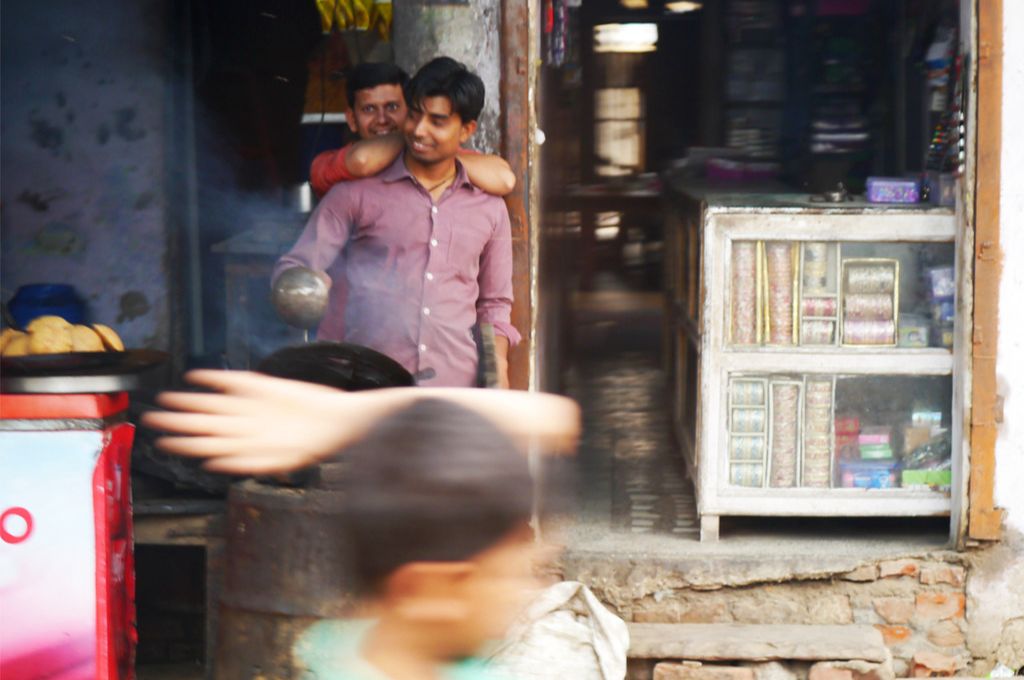 A man resting his hands on another man's shoulder from behind_gender programmes