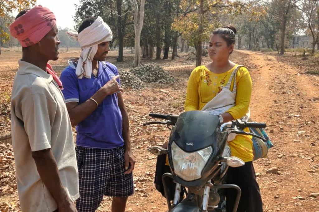 Bhagyashri on a bike talking to people-Adivasi