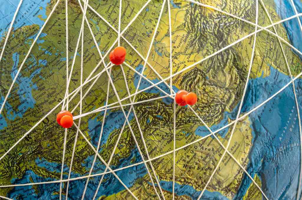 A globe with pins and threads interconnecting_philanthrophy