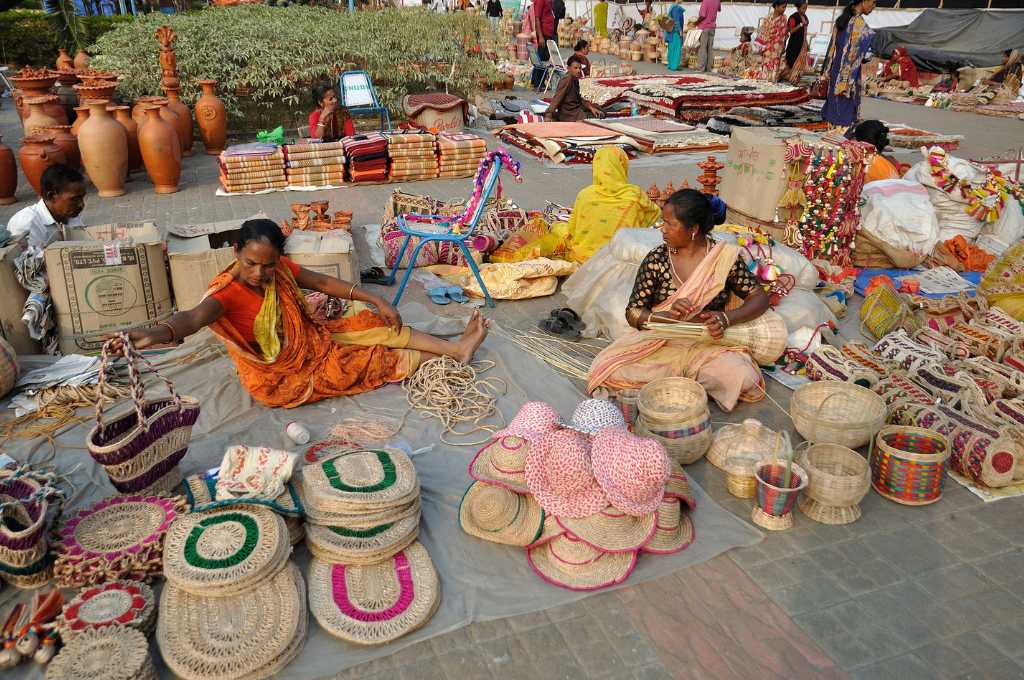 Two women are sitting on the floor, knitting the baskets_open web for digital commerce.