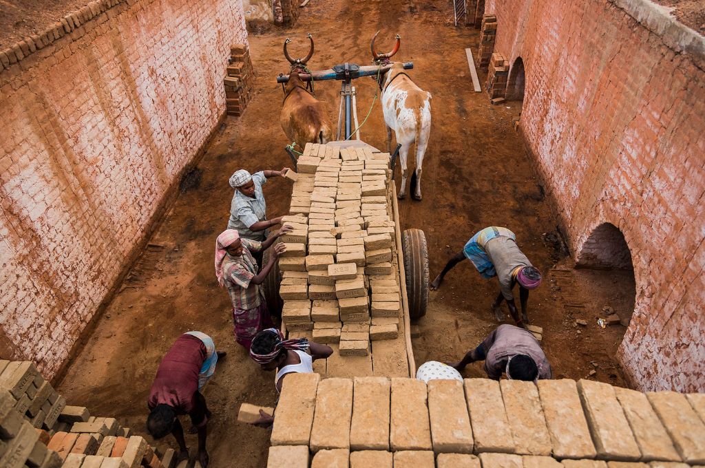 men loading brick on a cart