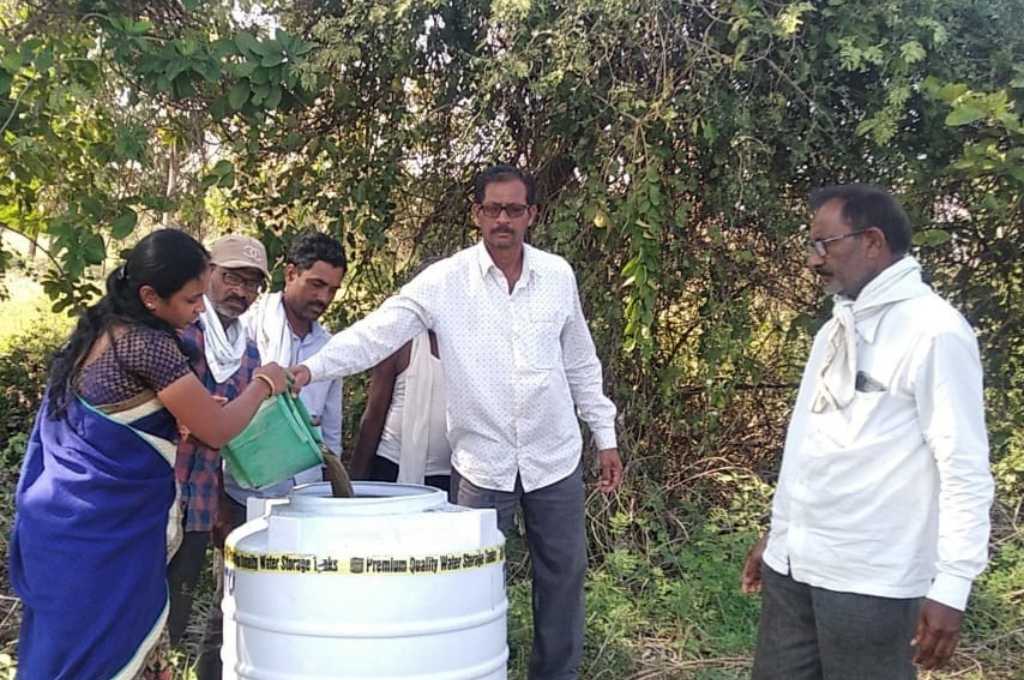 A woman and four men pouring water in a tank_sustainable agriculture