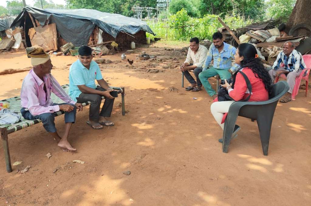 A group of men and women sitting on chairs in an open ground_Adivasi communities