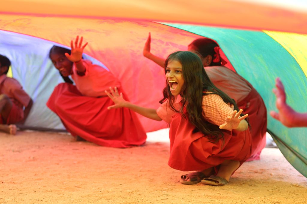 school girls playing under a parachute-early childhood education