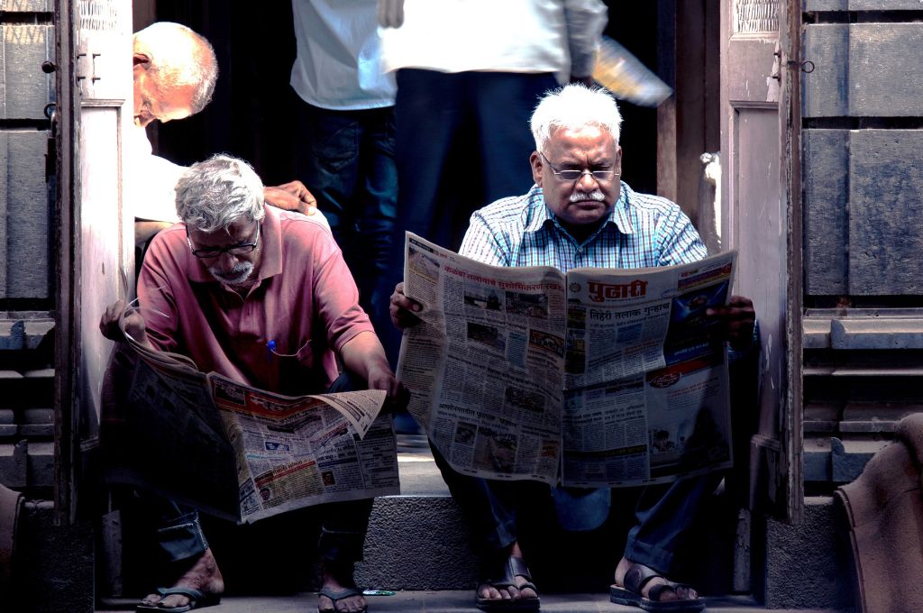 two men reading a newspaper-climate change