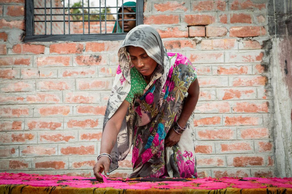woman in saree cutting up a pink cloth-women entrepreneurs