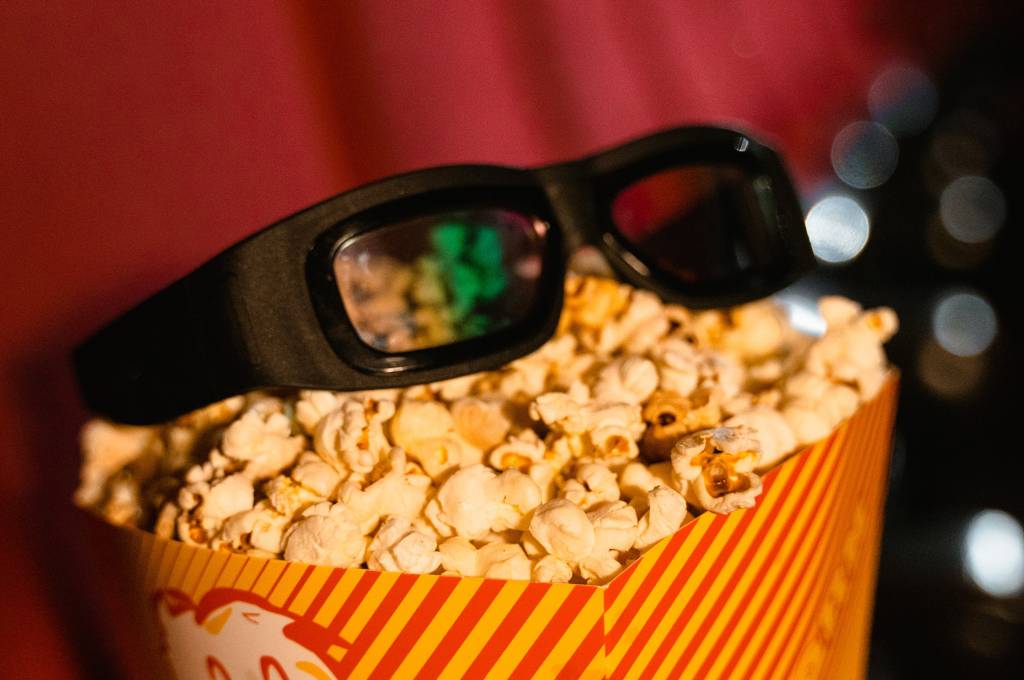 A tub of popcorn with 3D glasses on it_oscar movies
