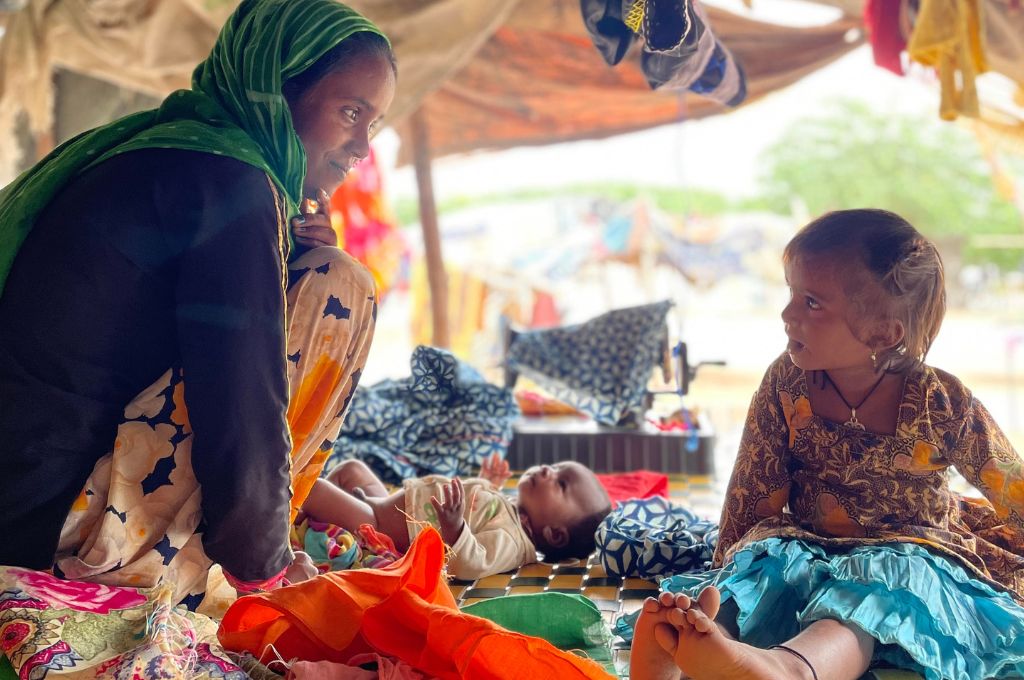 a former dancer from the nath kalbela tribe looking at one of her children--kalbelia