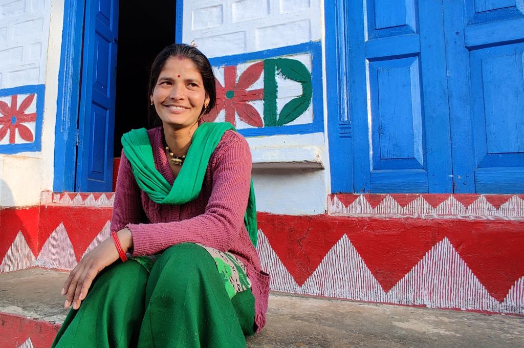 A woman sitting in front of a blue door--women entrepreneurs