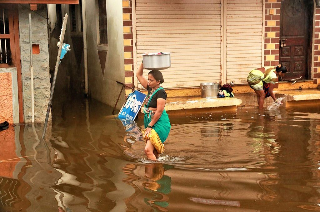 A woman walking through a flooded street_women and climate change