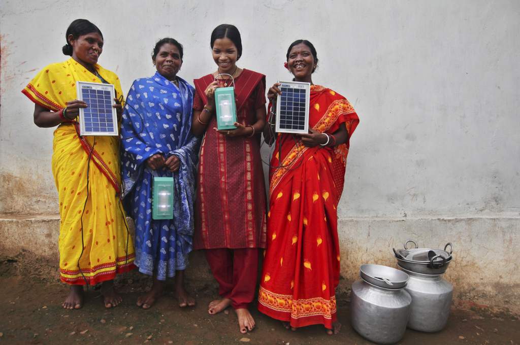 four women standing with solar panels in their hand_women and climate change