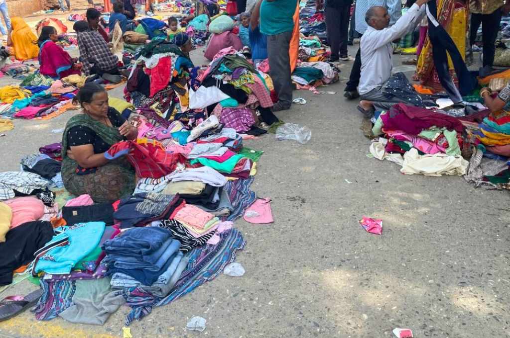 women sitting with piles of clothes in front of them--pheriwalis