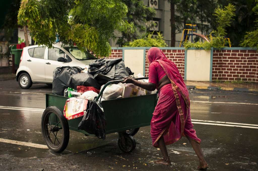 a woman hauling a wheelbarrow full of waste--waste-pickers