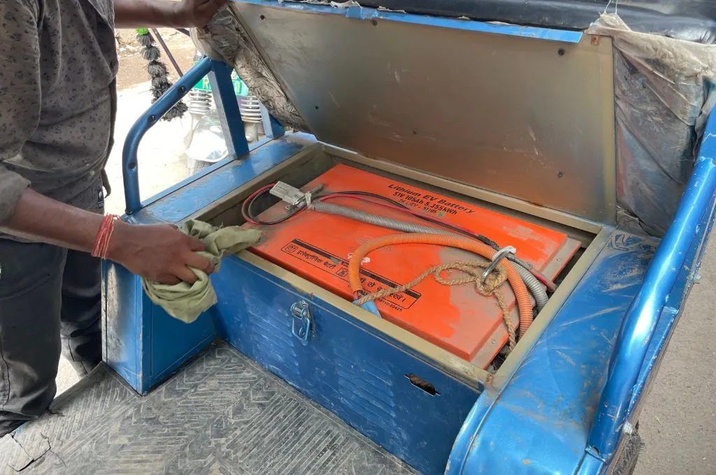 Dilip displaying the lithium-ion battery that powers his e-rickshaw.