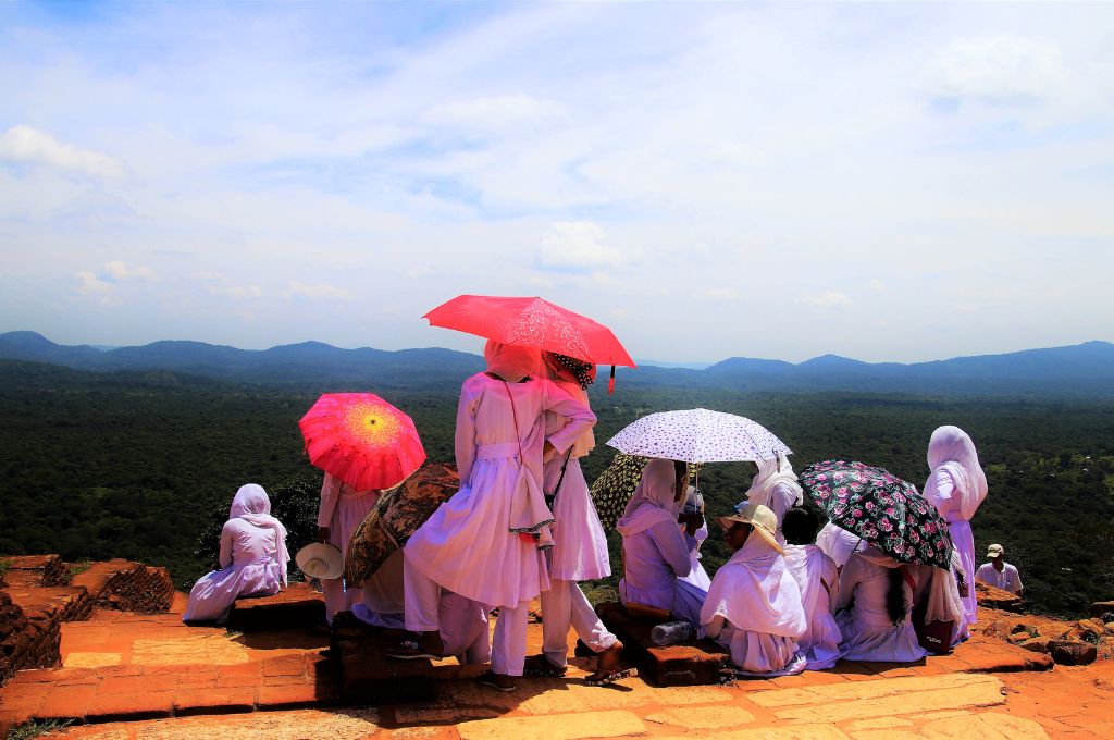 Women standing in a tourist spot holding umbrellas because of the heat_Heat action plan