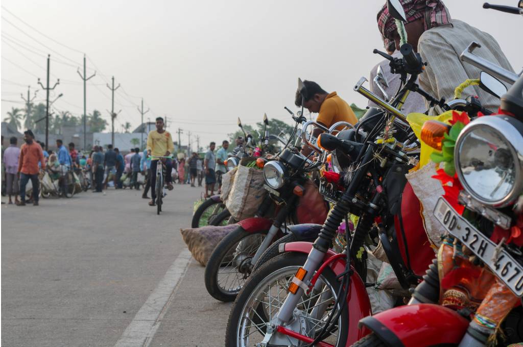 a line of motorbikes standing at a market-migration