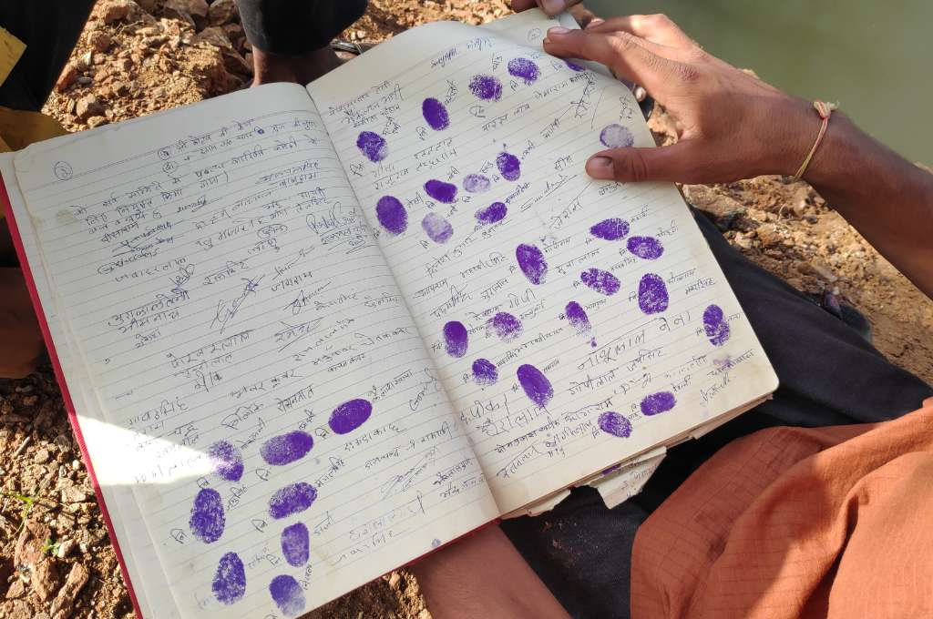 an open notebook with people's names and thumb prints--common land