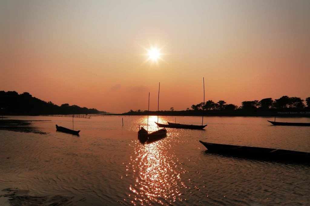 boats on a river in assam just before sunset