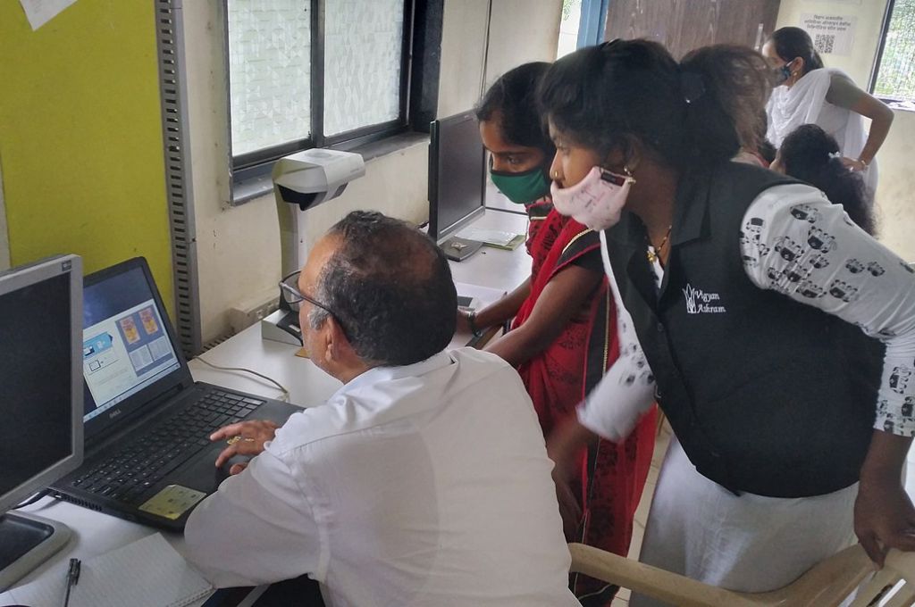 a woman teaching a man how to use a computer_digitisation