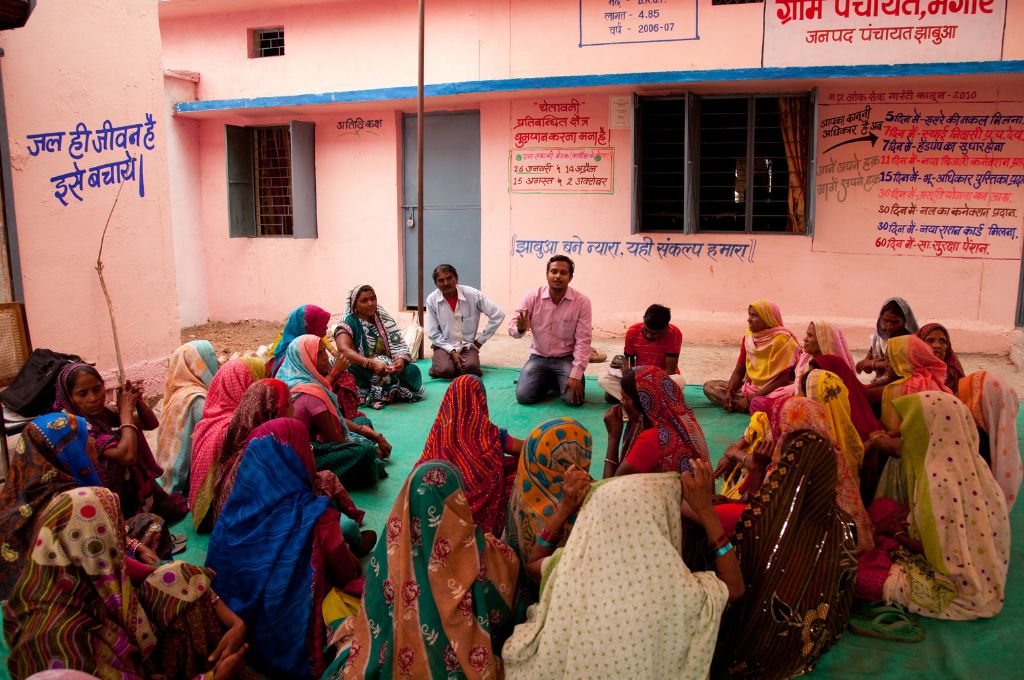 A group of women and men sitting in a courtyard as part of a gram panchayat  in madhya pradesh_local governance