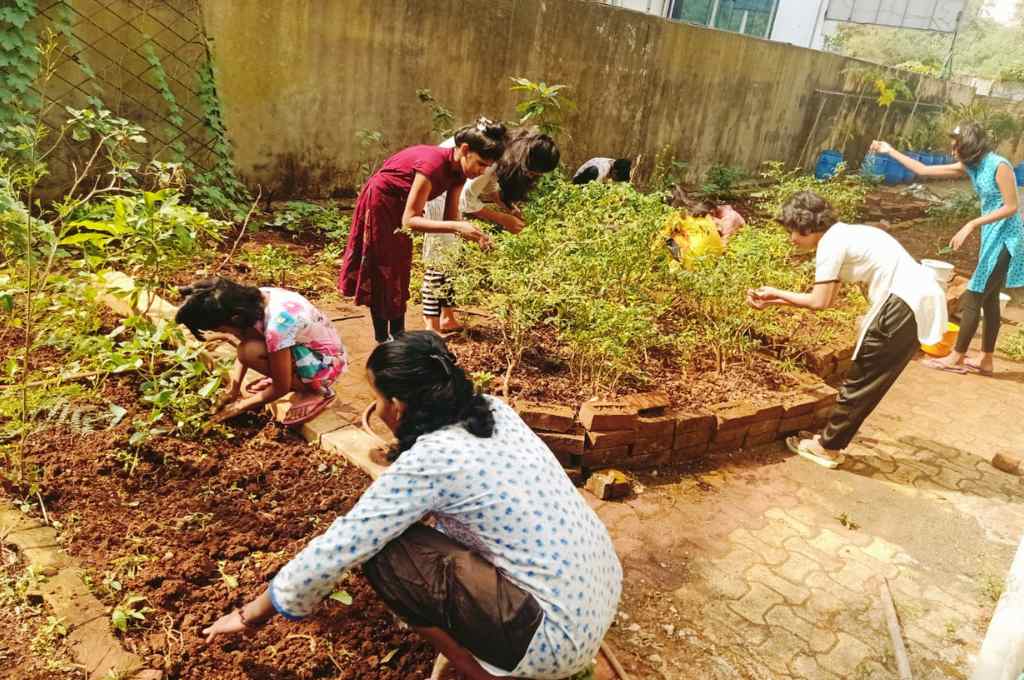 women and adolescent girls planting trees--children's home