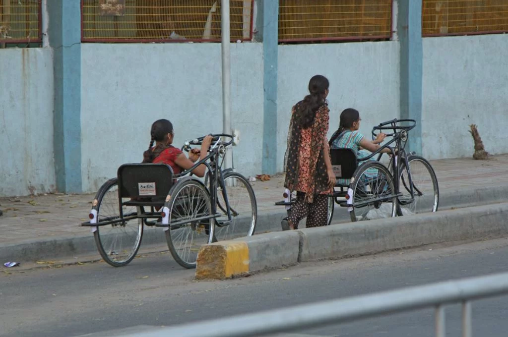 two young women with physical disability in a three-wheel bicycle-disabilities