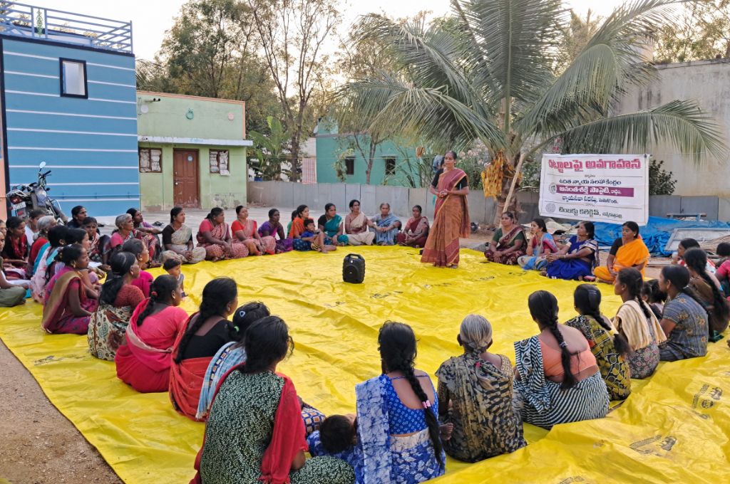 a group of women sitting in a circle on the ground--loan counselling