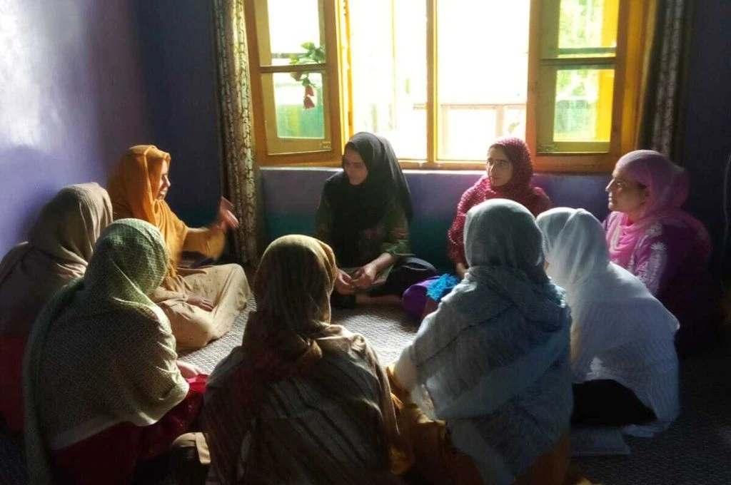 A group of women sit in a circle and have a discussion. - climate and gender