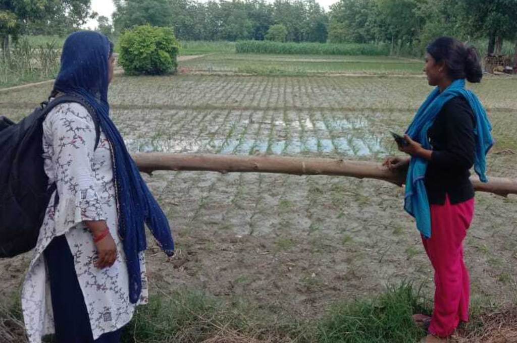 two women standing in a farm--rural working women