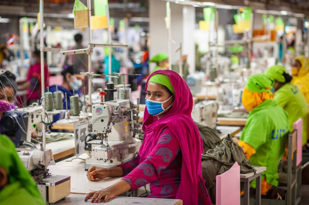 woman working in a garment factory with a mask covering her face--women employment laws