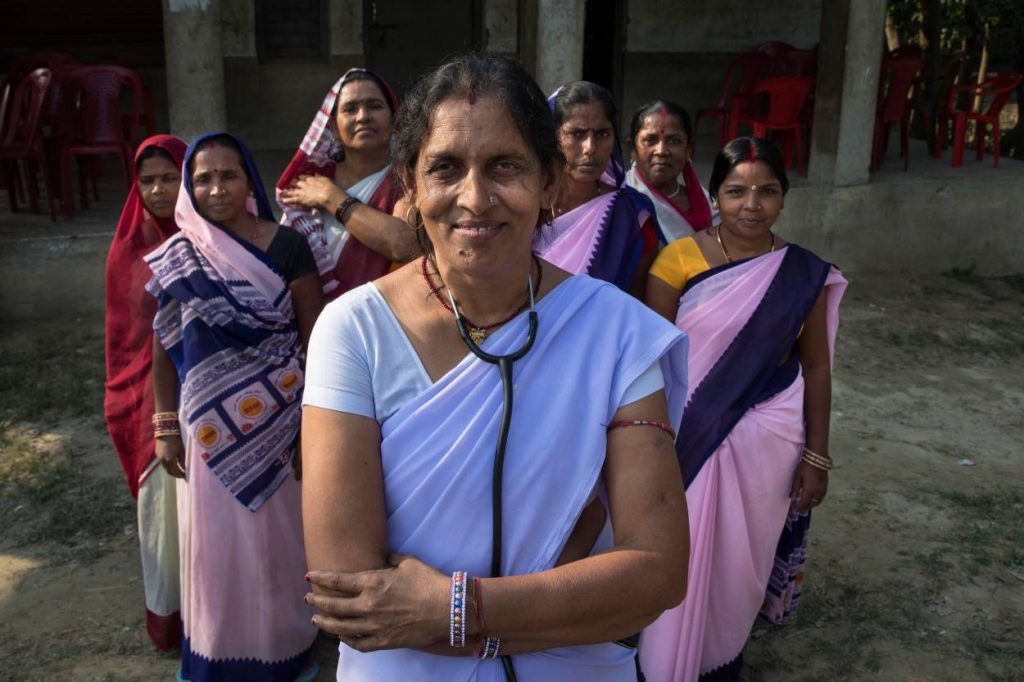 a group of women frontline workers smiling and looking at the camera--frontline health workers