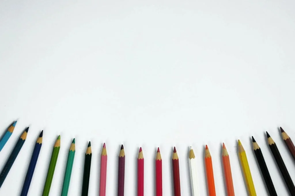 coloured pencils against a white background_m&e