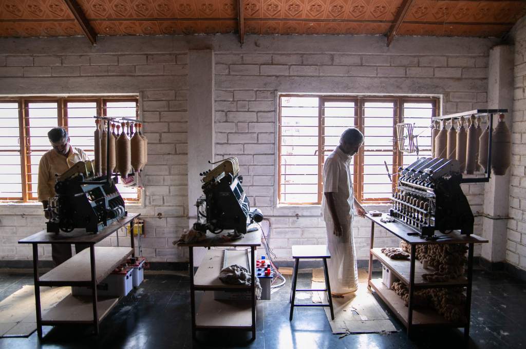 two men operating solar-powered textile-weaving machines--decentralised renewable energy