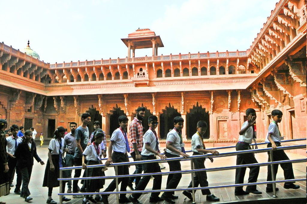 a group of school children in uniform walking in front of a fort_education