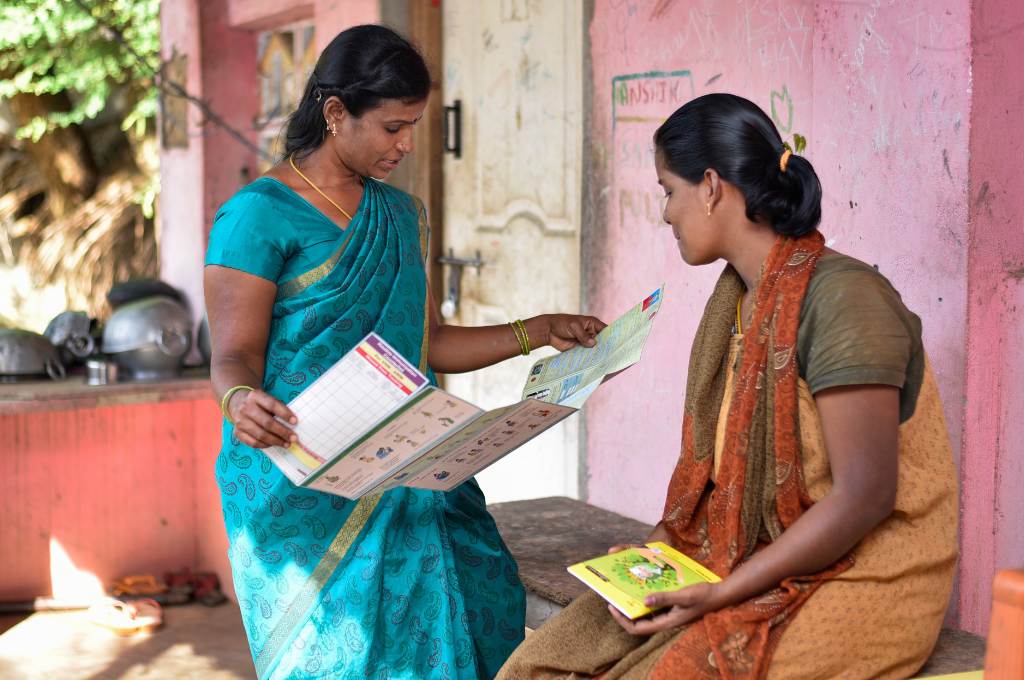 an ASHA worker reads a report of a pregnant woman at her house in Chennai, India--grassroots workers