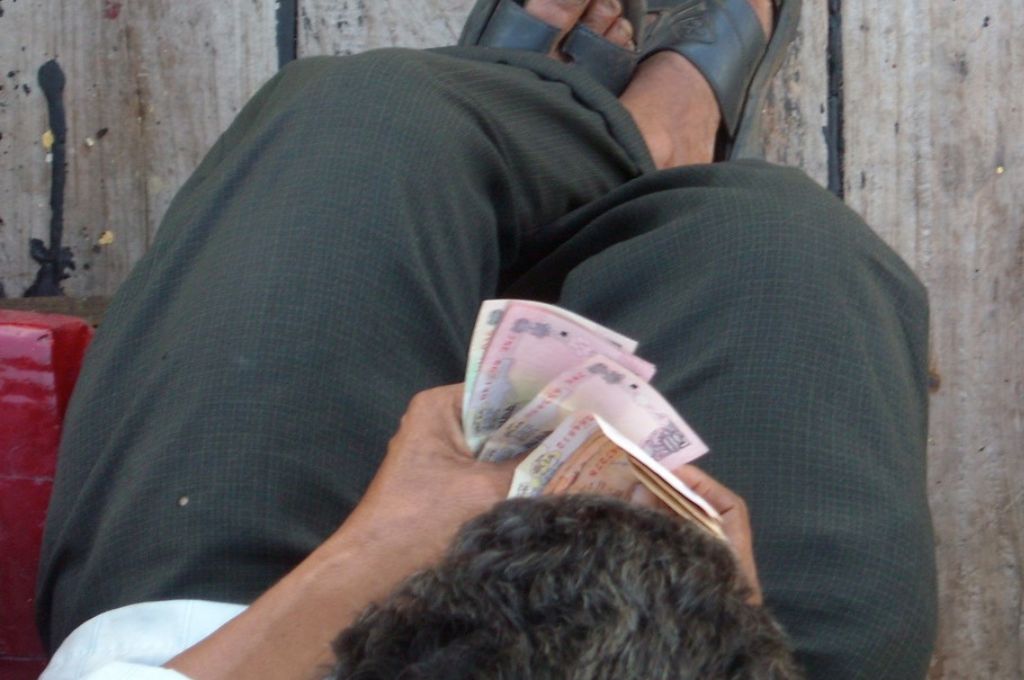 a man sitting and counting indian banknotes--union budget
