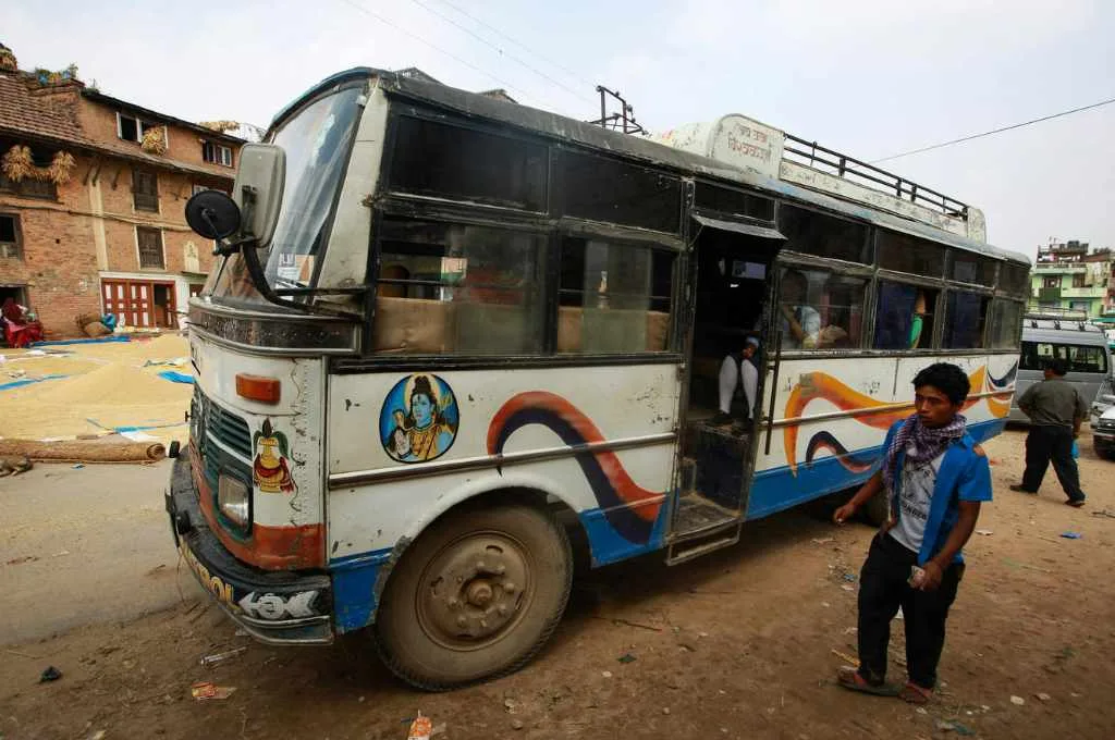 a young man standing next to a bus--sanitation access