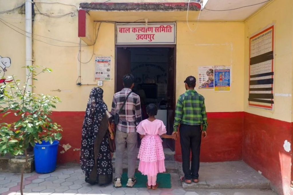 A family standing together in front of a foster care centre_foster care